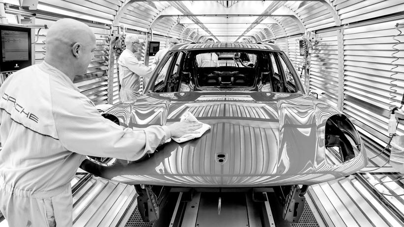 Wirtschaftspodcast "Ist das eine Blase?": Mitarbeiter der Lackiererei arbeiten an einem Porsche Macan im Werk Leipzig
