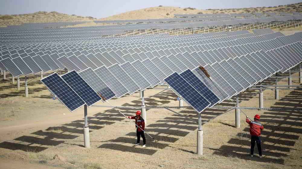 Volksrepublik: In einem Photovoltaik-Kraftwerk in Yinchuan entstauben Mitarbeiter nach windigem Wetter Photovoltaik-Panels.