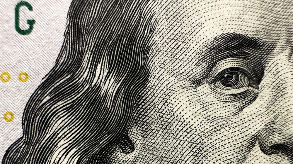 Finanzmärkte und Irankrieg: Benjamin Franklin ziert eine Dollarnote. Aber wie viel kann man sich für 100 US-Dollar kaufen? Durch den Krieg steigt die Gefahr von Börsenschock und Inflation.