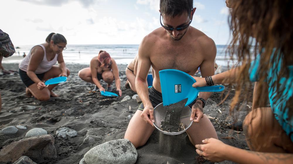 Plastikmüll: Spanische Freiwillige filtern an der Küste Plastikteile aus dem Sand.
