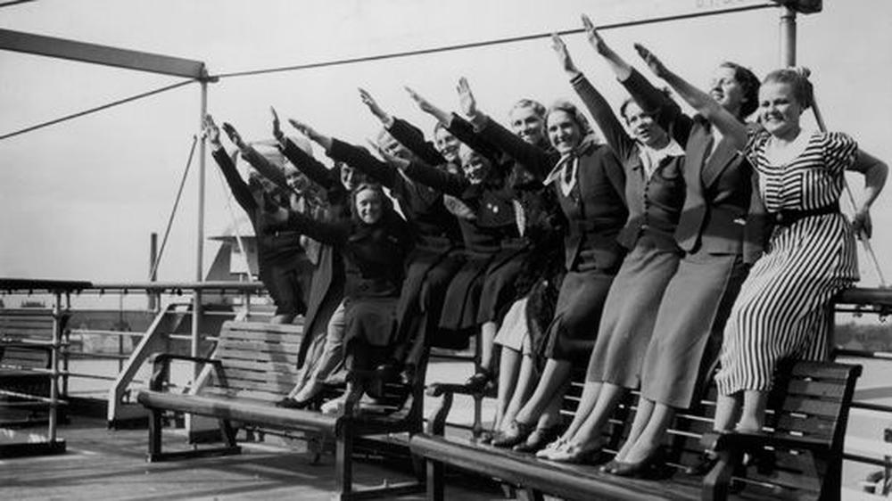 Einige Frauen machen den Hitlergruß an Deck eines Kreuzfahrtschiffs im April 1938.