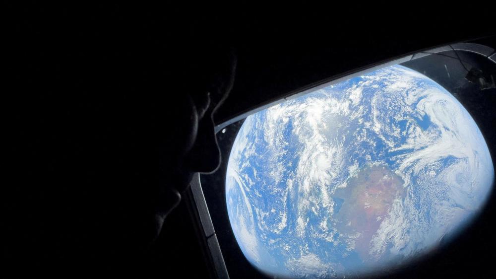 NASA astronaut and Artemis II Commander Reid Wiseman peers out of one of the Orion spacecraft's main cabin windows, looking back at Earth, as the crew travels towards the Moon April 2, 2026. NASA/Handout via REUTERS. THIS IMAGE HAS BEEN SUPPLIED BY A THIRD PARTY. REFILE - CORRECTING YEAR FROM "2024" TO "2026".