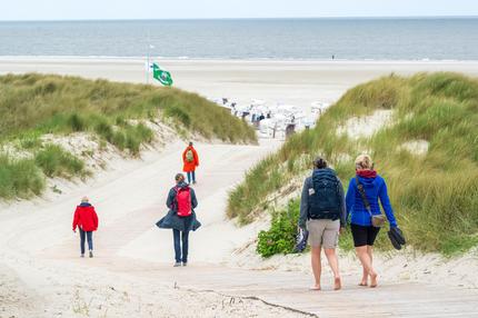 Klimawandel: Urlauber laufen zum Strand der ostfriesischen Insel Spiekeroog am 04.06.2025.