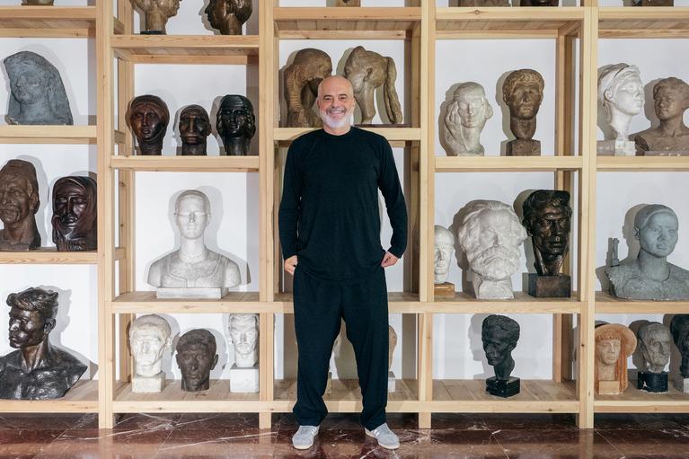 Edi Rama: Edi Rama vor einem Regal mit seinen Skulpturen. 1999 und 2003 hat er auf der Biennale in Venedig ausgestellt.