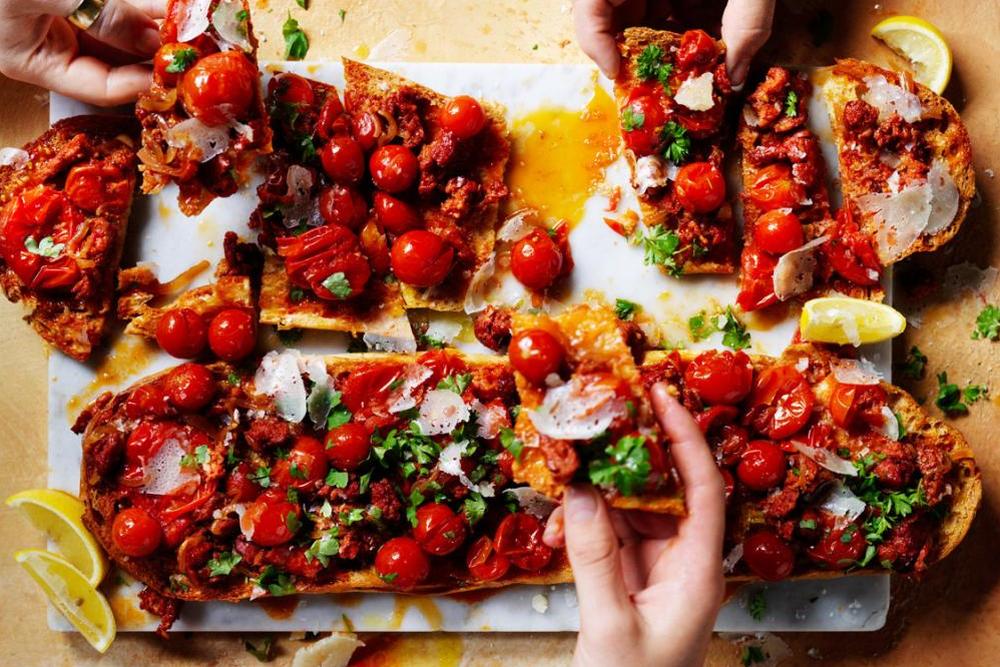 Tomaten-Knoblauch-Brot mit Chorizo: Für einen zusätzlichen Kick können Sie die Toasts mit knusprigen Kapern, Sardellen, dünn geschnittenem Jamón oder Chili bestreuen.