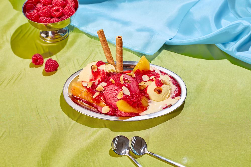 Pfirsich-Melba-Eisbecher: Die ersten europäischen Pfirsiche reifen schon im Mai – aber Dosenfrüchte schmecken sonst auch in diesem Eisrezept.