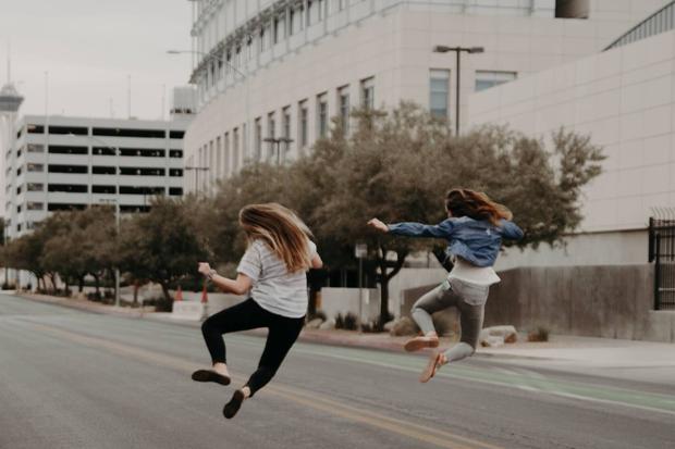 Hier zwei springende Frauen, die sich freuen.  